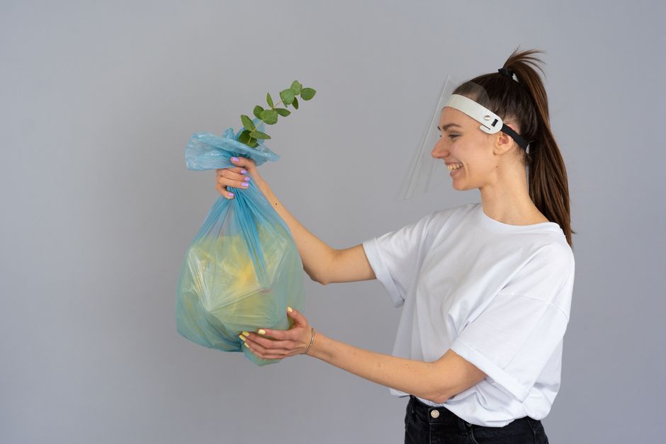 A large pile of mixed laundry consisting of various clothing items including t-shirts, pants, dresses, and accessories, all scattered and folded in a disorderly manner on a flat surface. The clothing